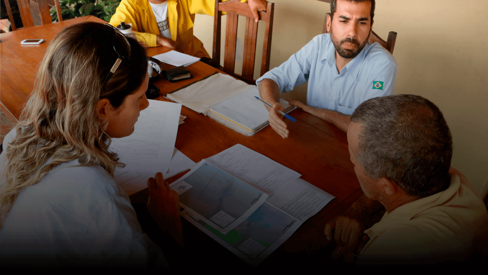 Terceiro slide, com quatro pessoas sentadas a mesa e mapas e anotações. Há um botão para produtores rurais se juntarem a Plataforma Produzindo Certo